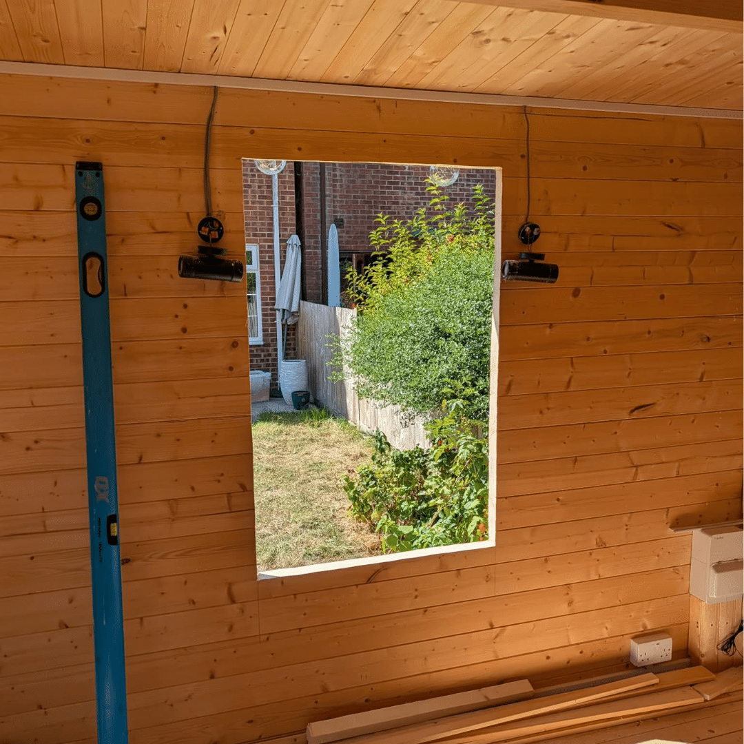 New window opening cut inside log cabin in Hempstead Medway